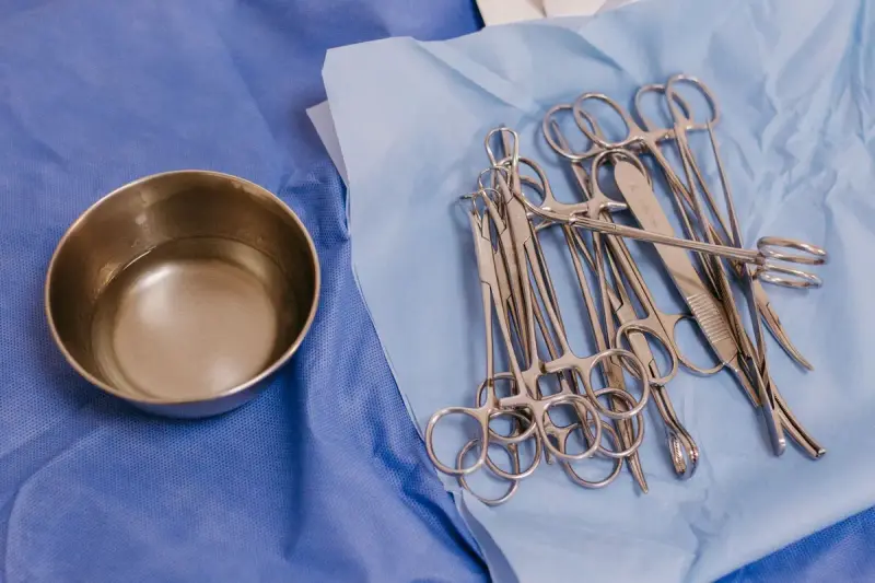 Sterile surgical instruments laid out on blue drapes before a procedure