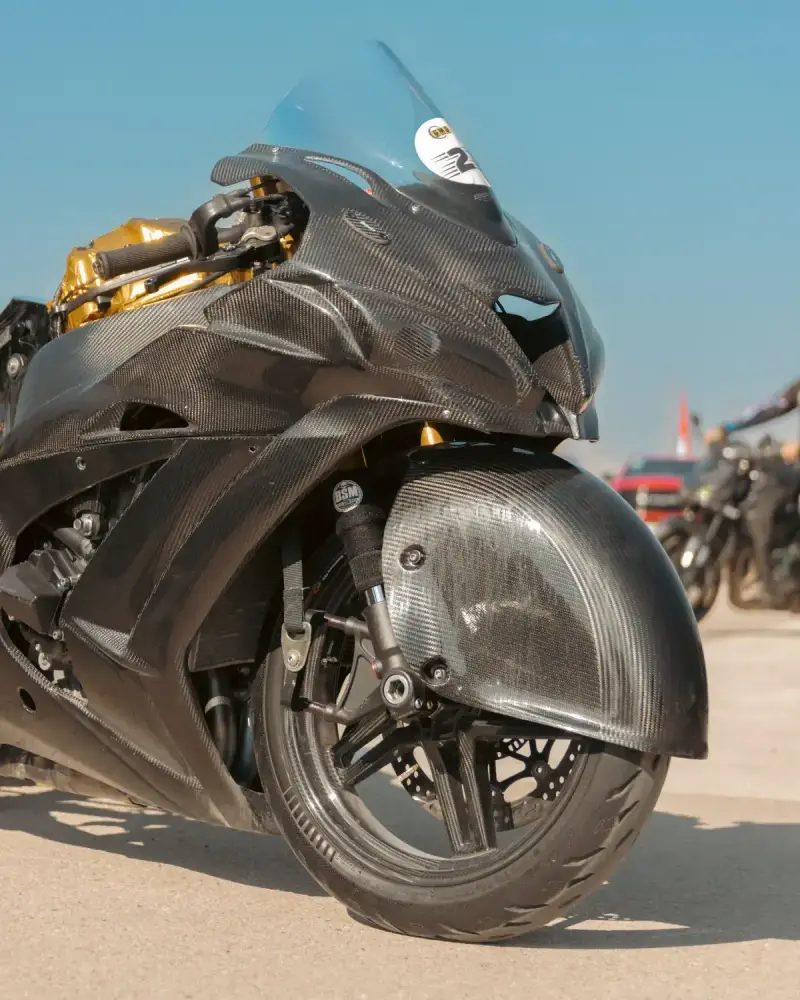 Close view of a motorcycle body panel with a visible carbon fiber weave