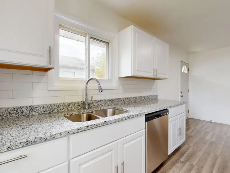 Bright modern kitchen with granite countertops, cabinets and stainless steel appliances