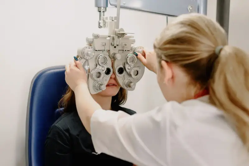 Optometrist adjusting a phoropter for a patient's eye examination