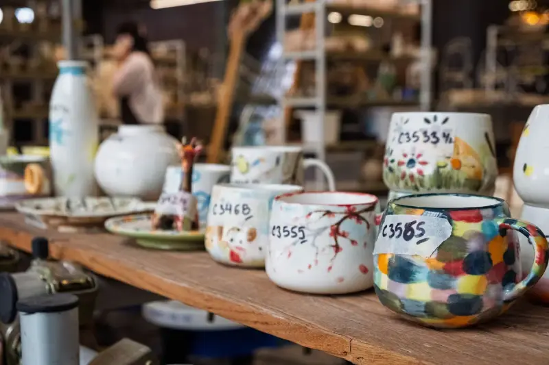 Handcrafted ceramic mugs in varied glazes displayed in an artisan shop