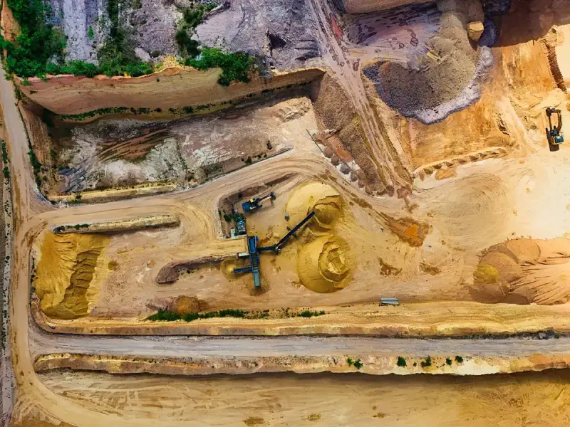 Top-down aerial view of a sand pit with a screening plant, conveyors and stockpiles
