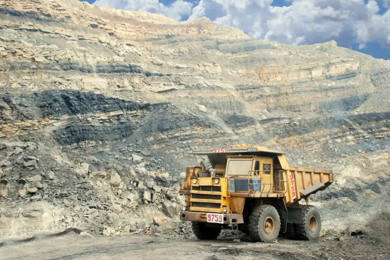 Large yellow mining truck parked in a rocky quarry
