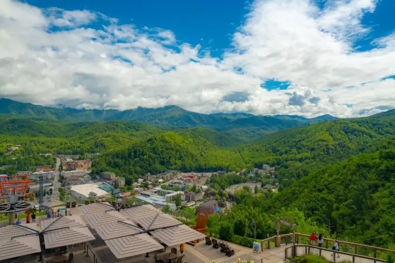 Aerial summer view of Gatlinburg's rooftops surrounded by green Smoky Mountain ridges