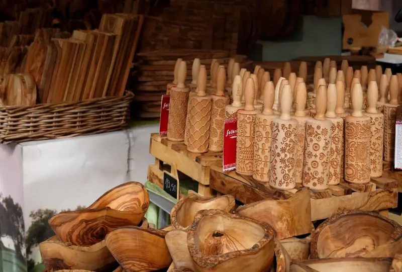 Carved decorative wooden rolling pins and bowls on a market table