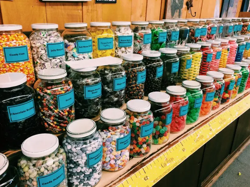 Rows of glass jars filled with colorful candies on a shop shelf