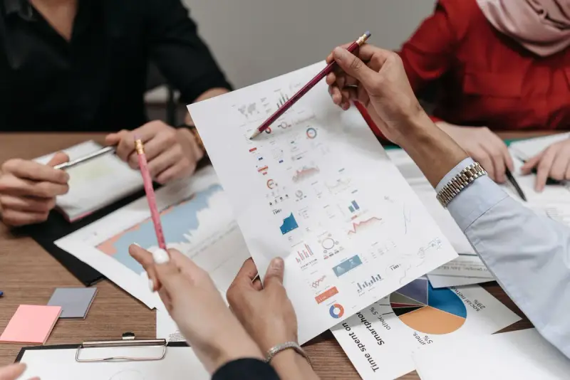 Team members analyzing reports and charts during a meeting