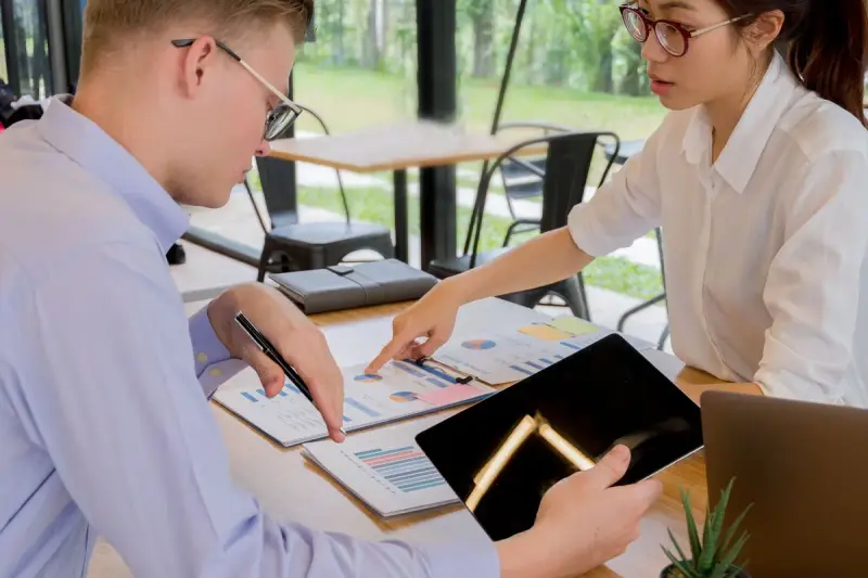 Two colleagues reviewing documents together at an office table