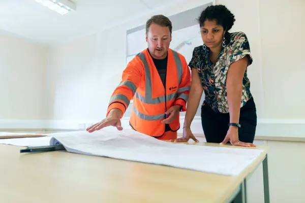 Engineers reviewing a technical drawing together in an office