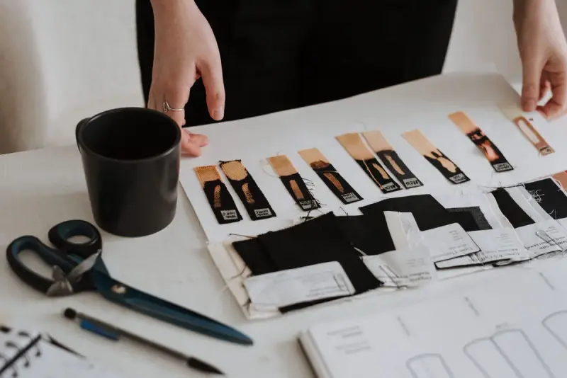 Designer laying out fabric samples and patterns beside scissors and a sketchbook