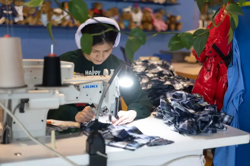 Workers sewing small garments at a factory in Vermont