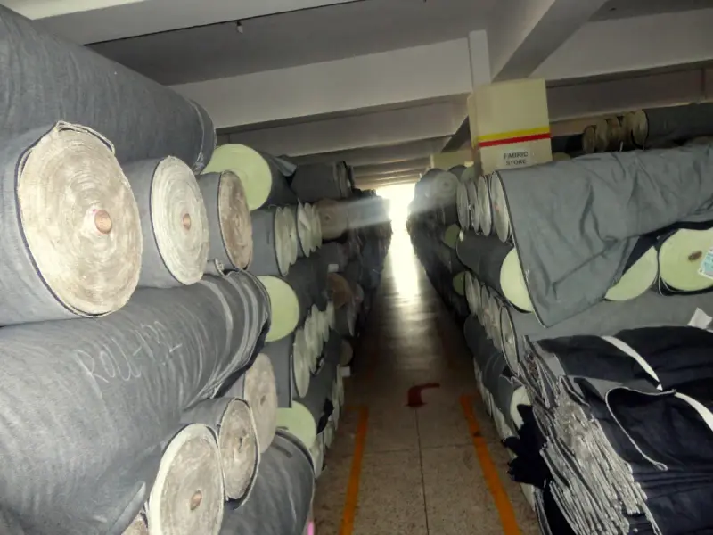 Rolls of denim fabric stacked in a fabric store