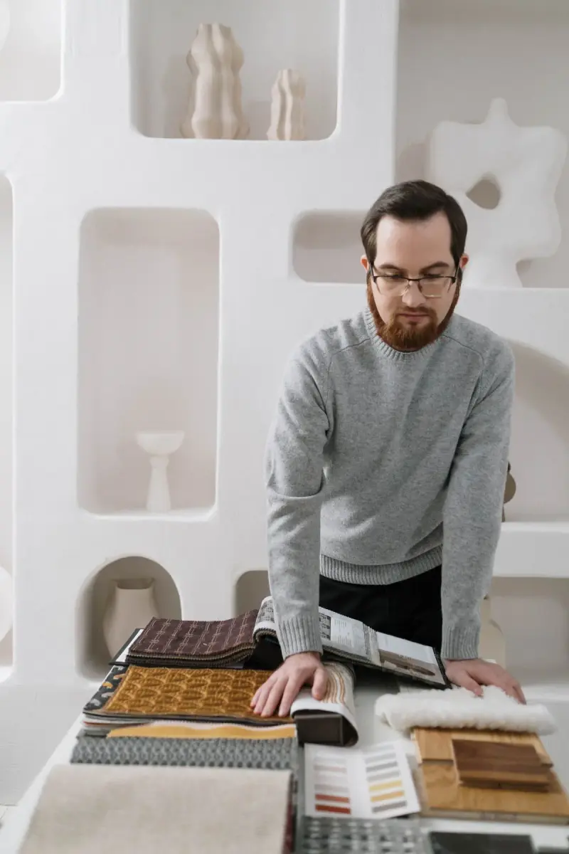 Designer reviewing fabric and material samples at a studio desk