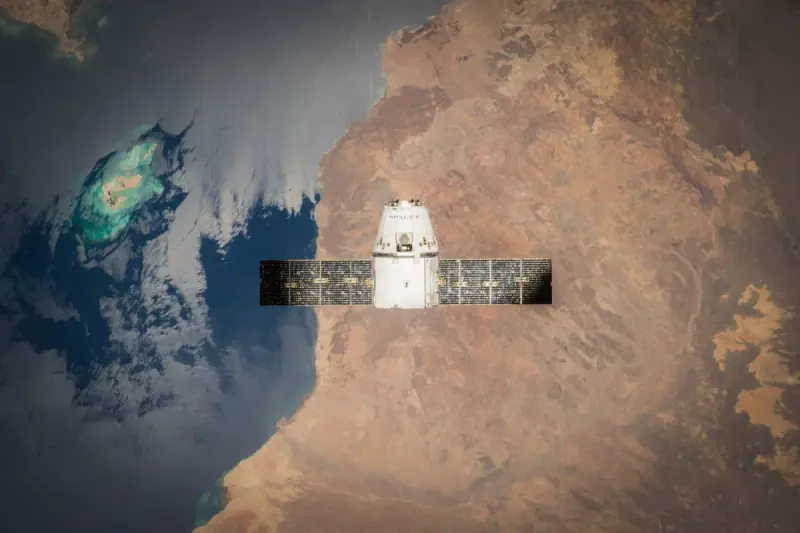 A spacecraft above Earth with ocean and land visible below.