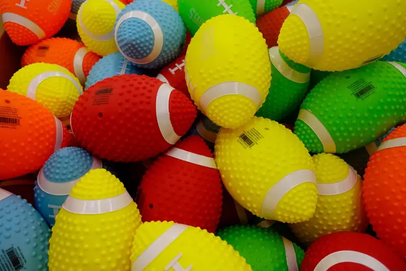 Pile of brightly colored textured toy footballs