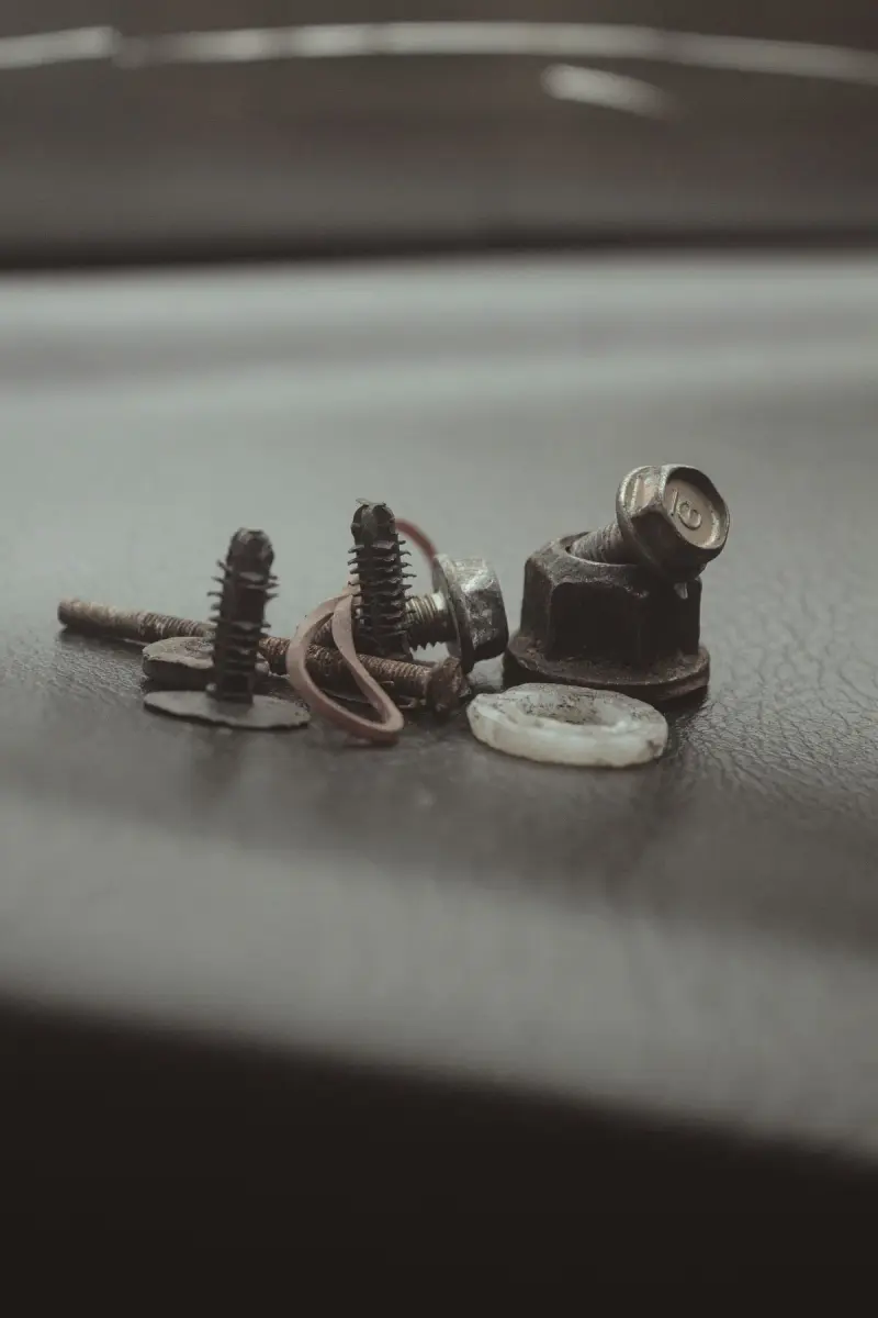 Assorted metal screws and bolts on a textured surface