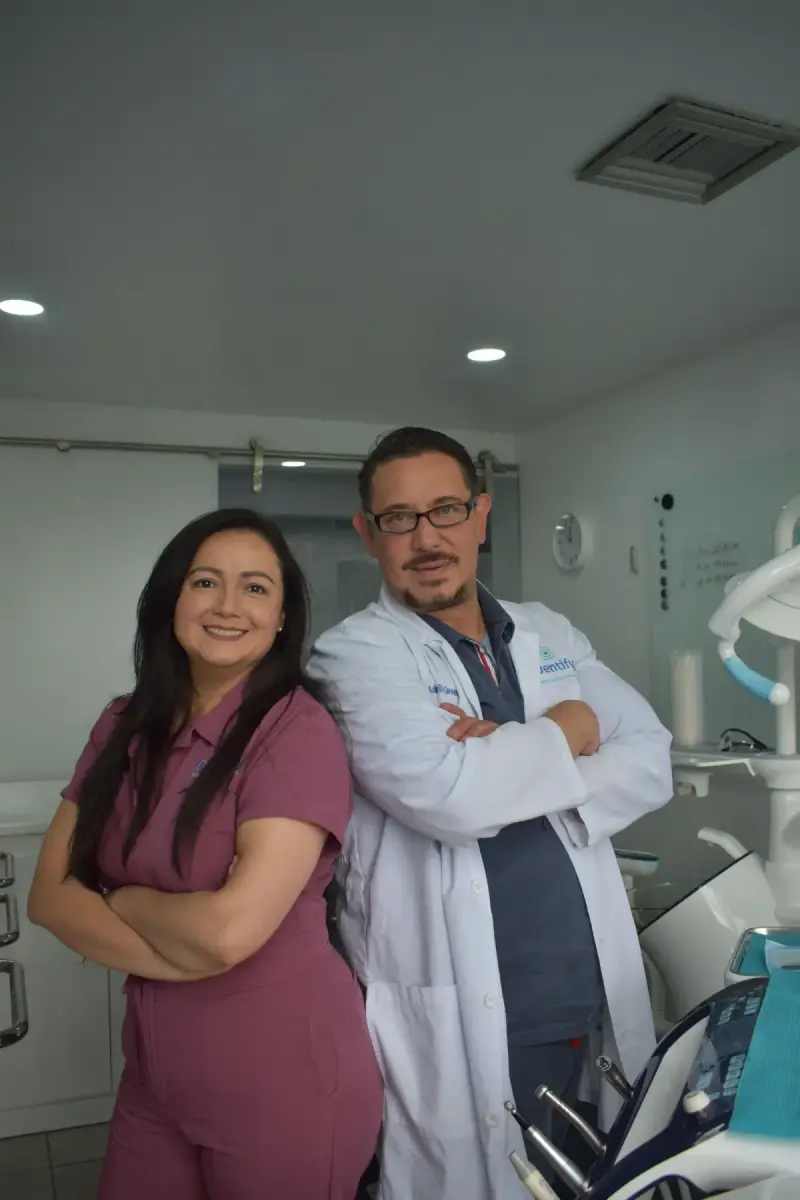 A dentist and female assistant standing together in a dental clinic