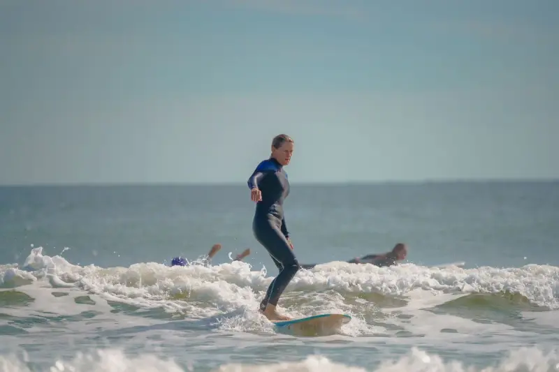 Woman in a wetsuit riding a small wave at Cocoa Beach, Florida