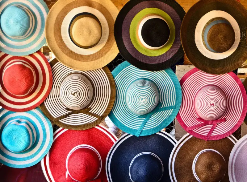 Colorful straw hats stacked on a market display