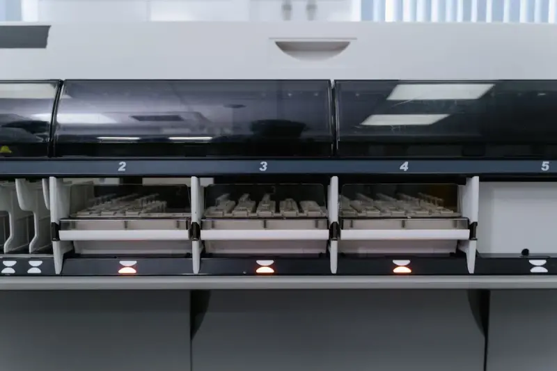 Automated laboratory analyzer loaded with racks of sample tubes