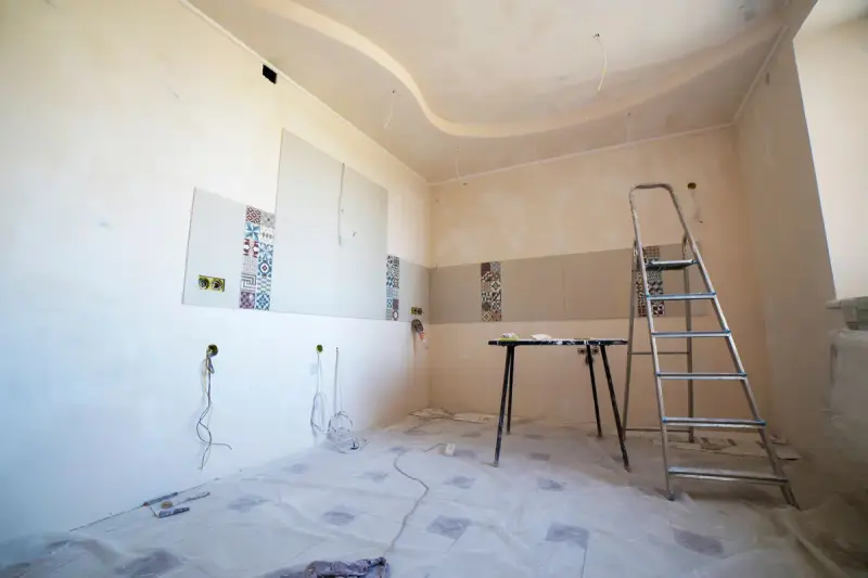 Room under renovation with tiles, paint and tools on the floor
