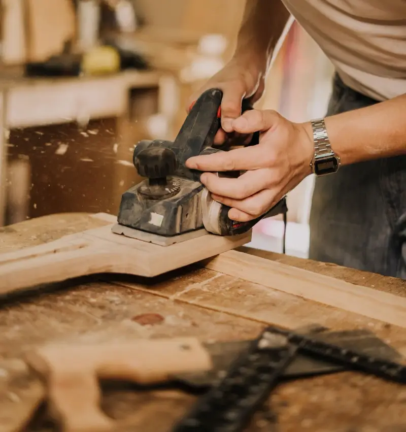 Close view of a sander smoothing a wooden board