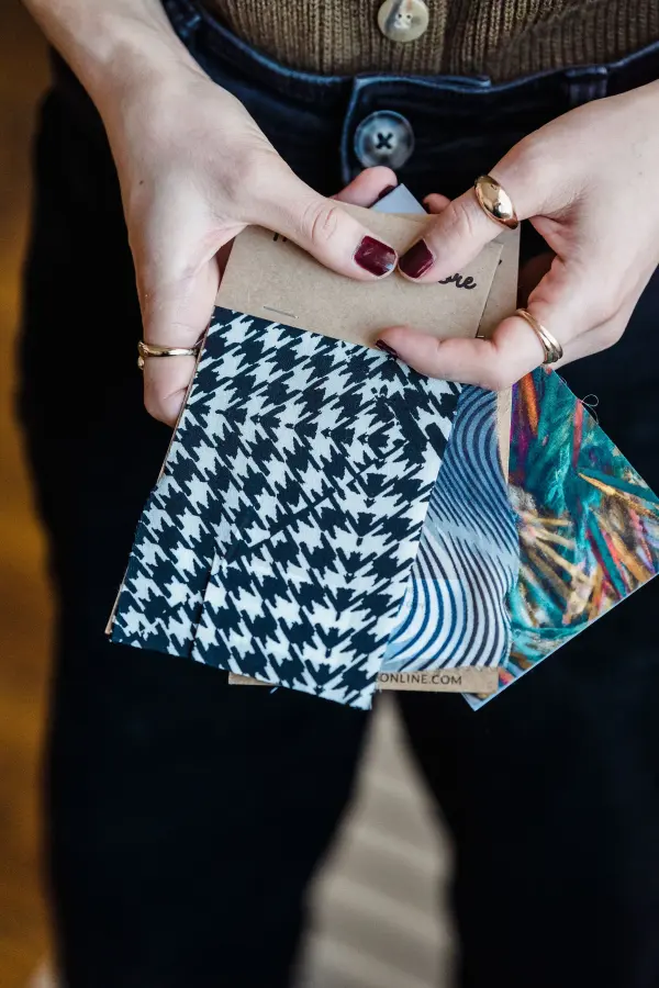 Hands holding and comparing a selection of fabric swatches