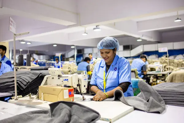 Textile factory workers at rows of industrial sewing machines