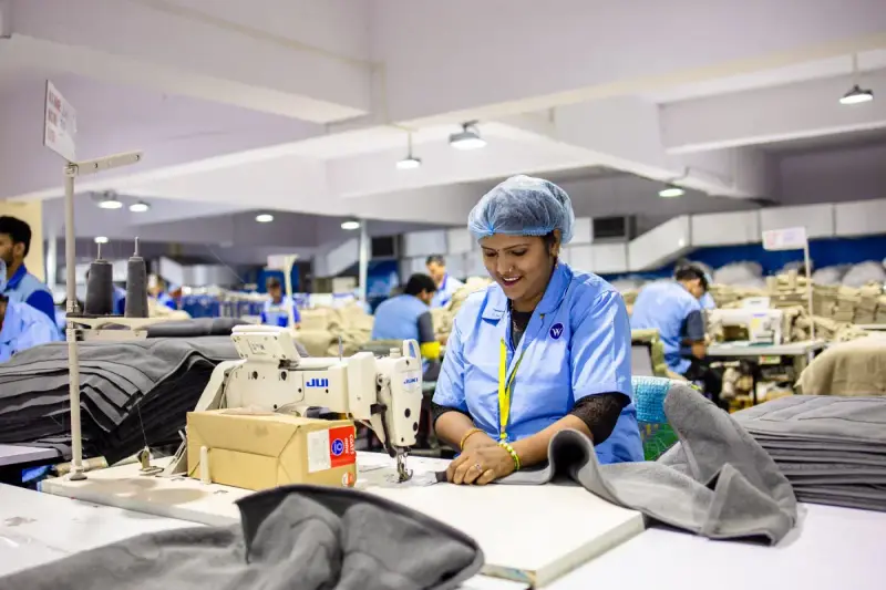 Textile factory workers at rows of industrial sewing machines