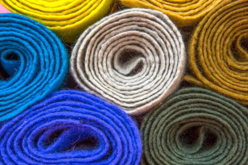 Rolls of blue, cream, yellow and green wool felt fabric