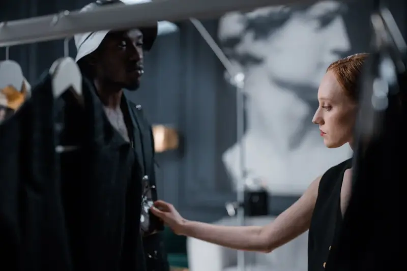 Two fashion designers fit a garment in a modern studio