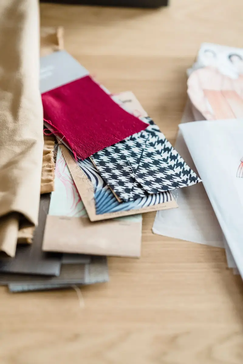 Pink, houndstooth and printed fabric samples with fashion sketches