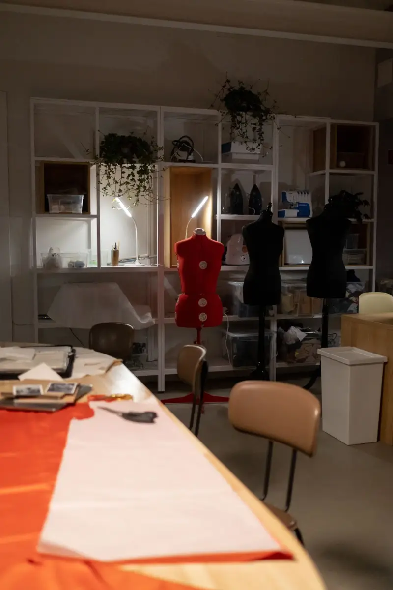Fashion studio with dress forms, shelves and a long cutting table
