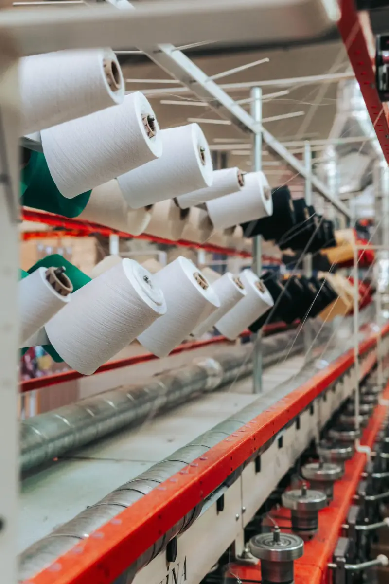 Rows of white and colored thread cones on industrial racks