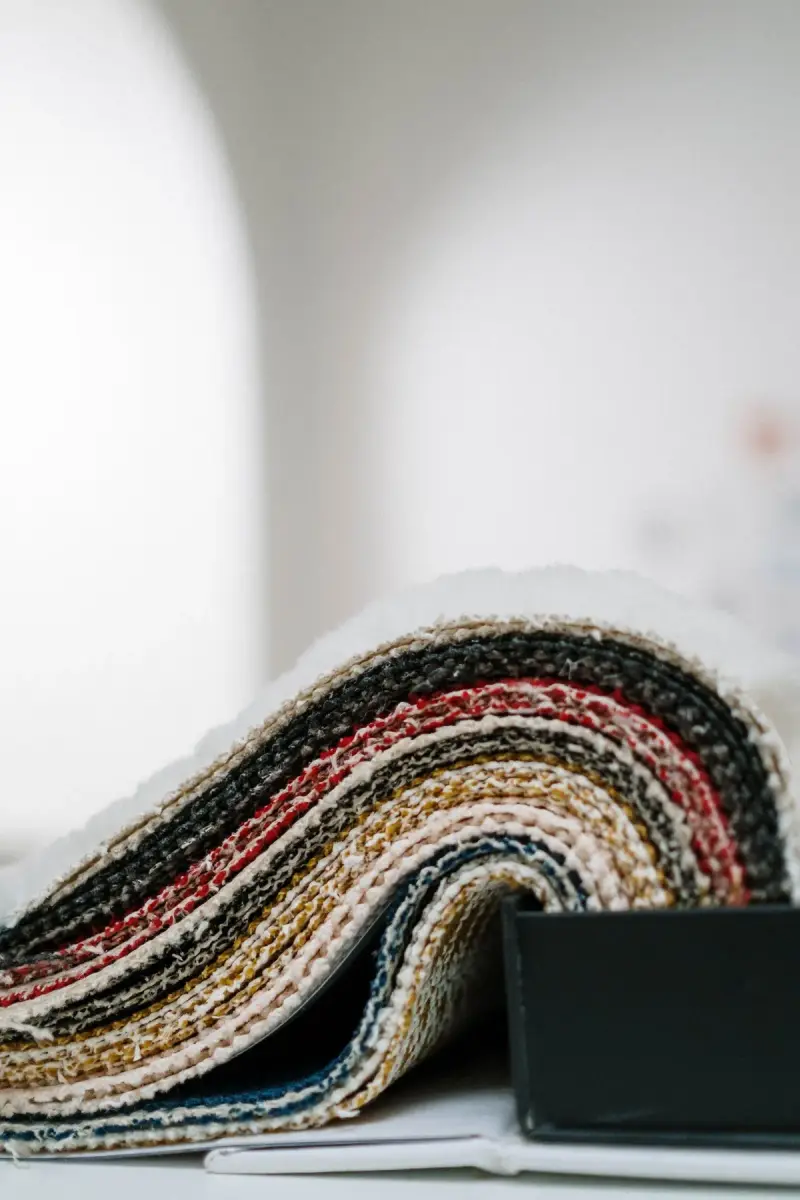 Edge of a rolled multicolored knit fabric against a white background