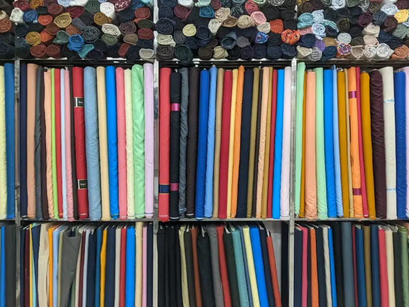 Colorful fabric rolls stacked on shelves in a textile shop
