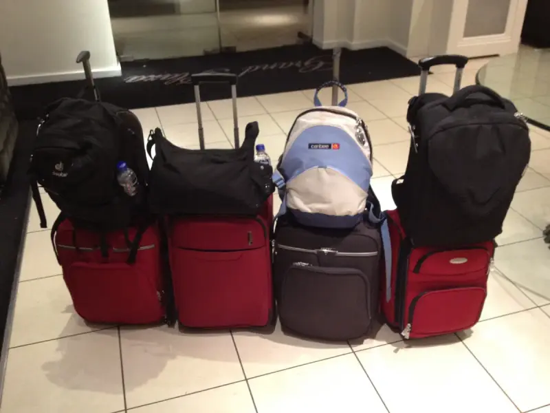 A pile of suitcases and travel bags packed for a trip