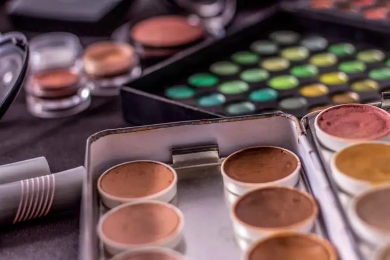 Open pro kit of cream foundations and eyeshadow pans on a table