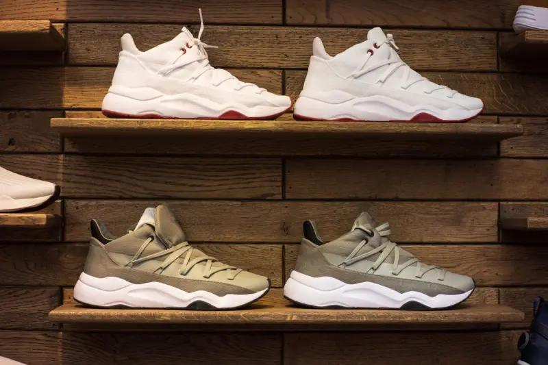 Neutral-toned sneakers displayed on rustic wooden wall shelves