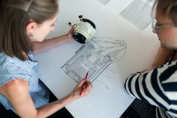 Engineers reviewing an equipment drawing; technical design reference.