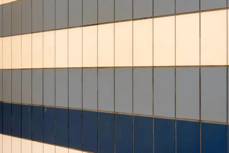 Wall of blue, gray and cream ceramic tile in horizontal bands