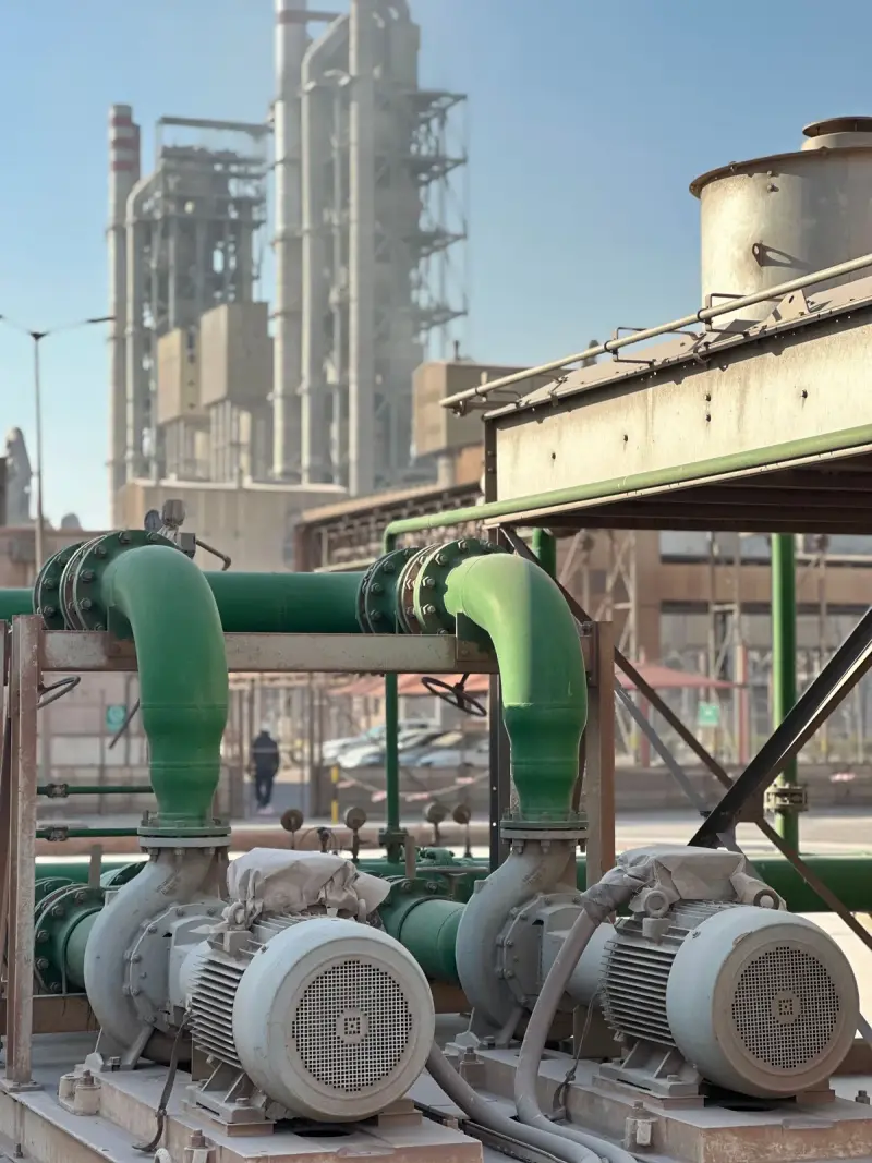 Row of industrial pumps and piping inside a power plant