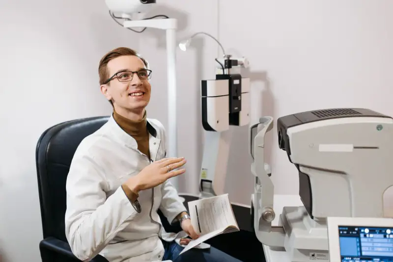 Optometrist smiling during an eye examination in a modern office