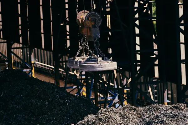 Industrial magnet lifting scrap metal at a recycling facility