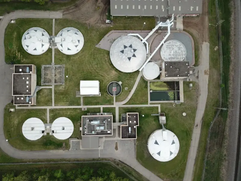 Water treatment facility with covered round tanks and buildings seen from overhead