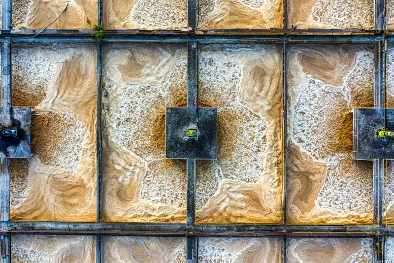 Swirling foam patterns in a grid of aeration basins seen straight down