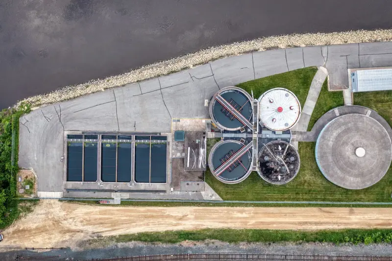 Top-down view of a riverside water treatment plant with basins and clarifiers in Red Wing, Minnesota