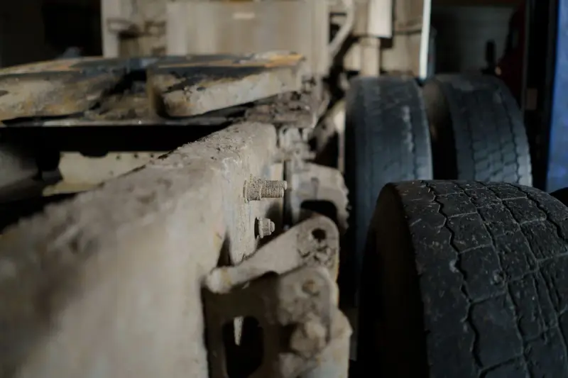Close view of a heavy truck chassis, axle and tires in a garage