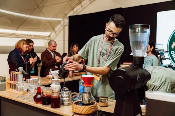 Barista preparing coffee with visitors watching at a festival in Baku