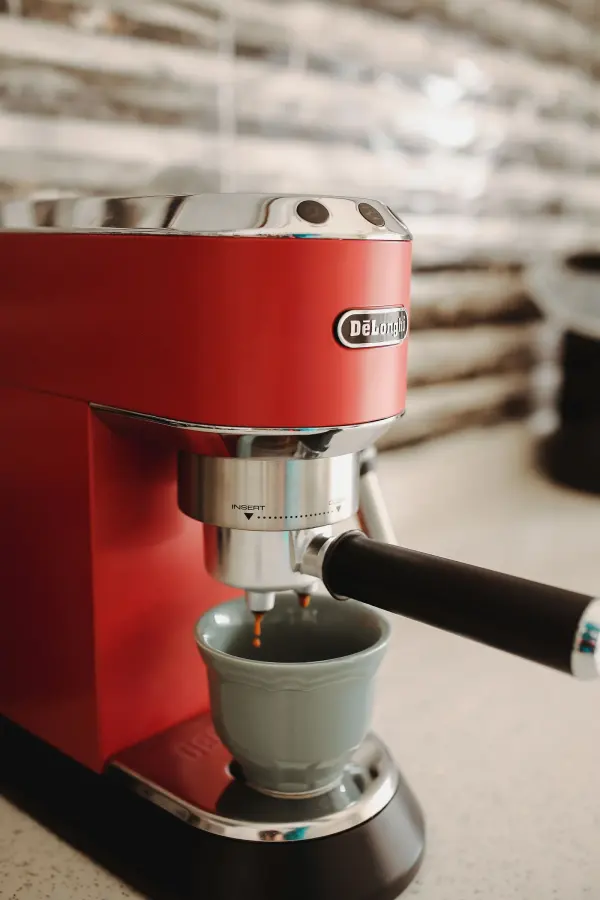 Red espresso machine brewing coffee